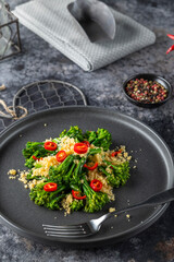 Delicious broccolini salad with toasted breadcrumbs and chili pepper flakes on black plate