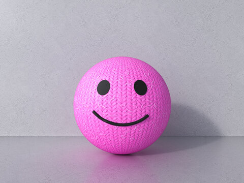 3D knitted wool smiley emoji with happy facial expression indoors