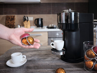 Close-up a man holds in his hand a variety of multi-colored capsules for making coffee. Convenient...