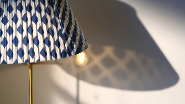 Shweshwe fabric lampshade casting geometric indigo shadows from a Scandinavian brass floor lamp in moody lighting. 