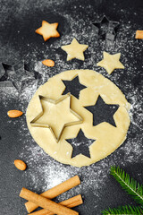 Christmas star cookies baking with flour and ingredients on dark table for food blog and seasonal...