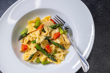 Farfalle pasta with green asparagus, cherry tomatoes and chicken
