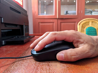 Person hand holding a wired computer mouse