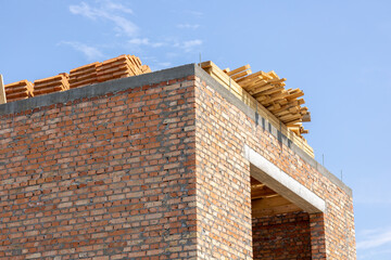 Workers are busy on a construction site where a brick building is being erected, showcasing wooden...