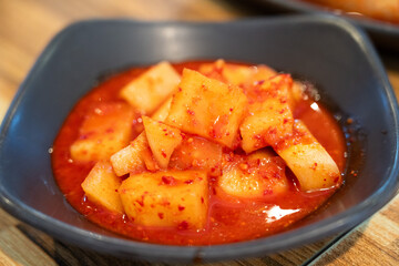 Spicy Korean Radish Kimchi in a Black Bowl