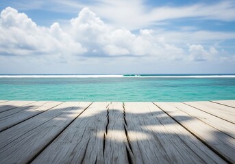 Fototapeta premium Wooden deck overlooking a serene turquoise ocean with white clouds in a bright blue sky, perfect for a tropical vacation getaway