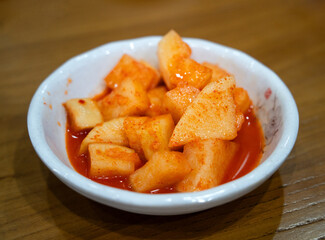 Spicy Korean Radish Kimchi in a Black Bowl