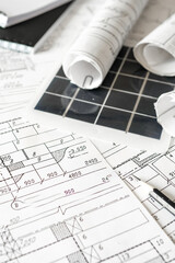 sustainable architecture tools and materials: blueprints, solar panel, wood textures, fabric swatches, and stones. Eco-friendly design, conscious construction and green innovation.