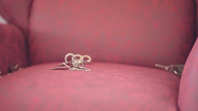 Keys in motion while falling onto a red sofa in soft focus