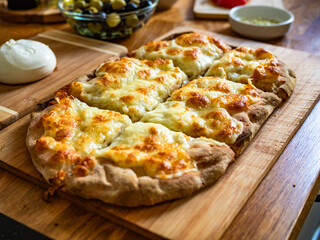 Pinsa bianca white pizza on wooden kitchen table	