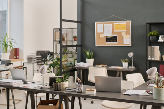 No people wide interior shot of modern office equipped with minimalistic furniture and laptops, copy space