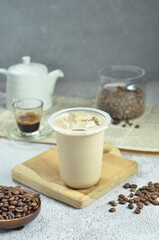 Ice coffee in a plastic cup with brown sugar and ice cubes and beans