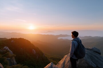 Young asian male backpacker watching sunrise over mountain landscape