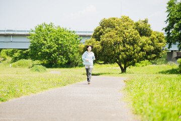 Obraz premium ランニングをする若い女性 スポーツイメージ