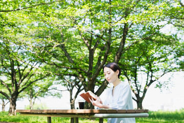 屋外で読書をする若い女性　ライフスタイルイメージ