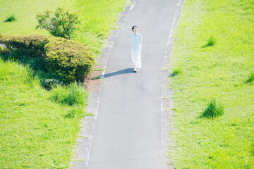 散歩道を歩く若い女性　ライフスタイルイメージ