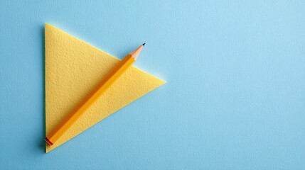 Yellow Pencil Diagonally Placed on Yellow Triangular Paper Against Light Blue Background