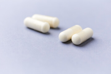 Creatine capsules on paper background. Soft focus. Close up. Copy space.	