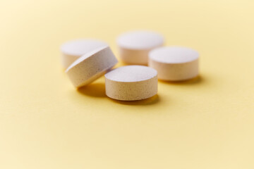 Creatine tablets on paper background. Soft focus. Close up. Copy space	