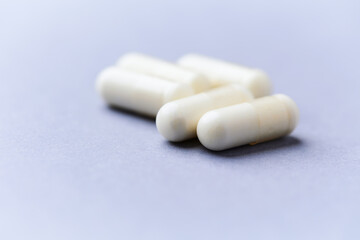 Creatine capsules on paper background. Soft focus. Close up. Copy space.	