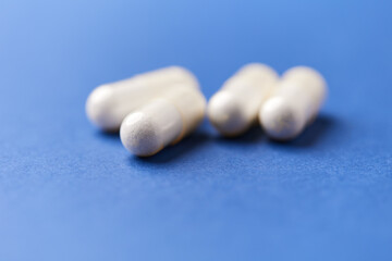 Creatine capsules on paper background. Soft focus. Close up. Copy space.	
