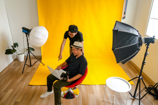 Photographer and Model Looking at Photo Result on Laptop at Studio Room