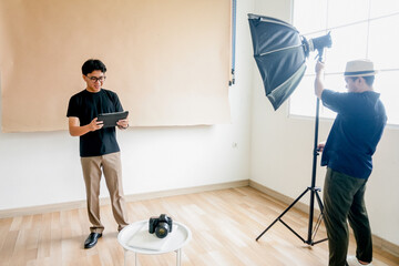 Two Male Doing Studio Preparation Scene With Teamwork Between Lighting And Digital Control