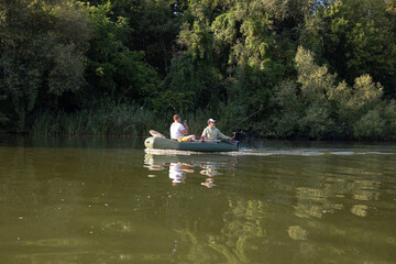 Father and son boating on a river and fishing
