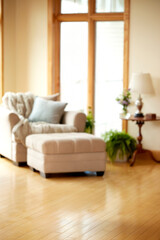 Beige armchair with ottoman and blanket by large window with lamp throw