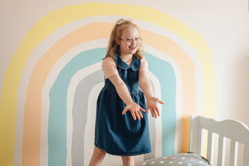 Smiling girl with Down syndrome in colorful room