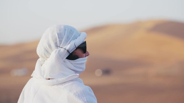 Person gazing at distant sand dunes in a serene Sahara desert landscape