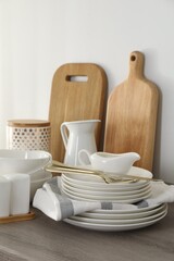 Different clean white dishware and cutting boards on counter in kitchen, closeup