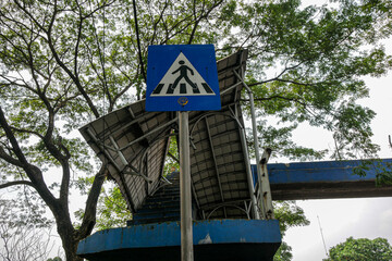 Drivers pass beside a damaged pedestrian bridge.
