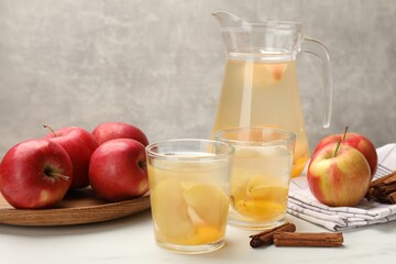 Tasty compot with apples and cinnamon on white table