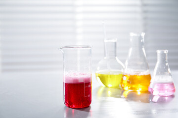 Laboratory glassware with different samples on light table indoors. Solution chemistry
