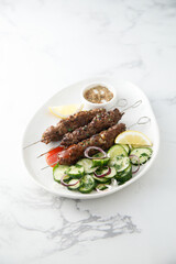 Traditional lamb kebab with cucumber salad