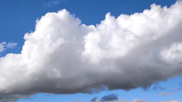 Enormus radiant cumulonimbus clouds move in the blue sky