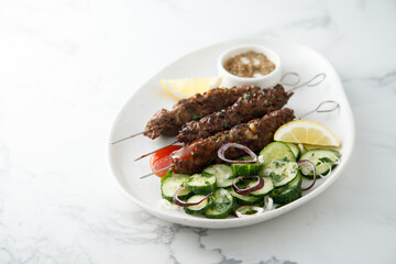 Traditional lamb kebab with cucumber salad