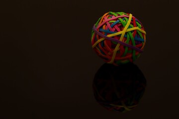 Colorful Rubber Band Ball with Reflection on a Dark Surface