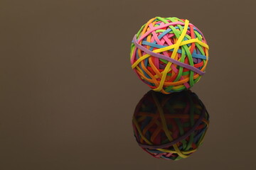 Colorful Rubber Band Ball with Reflection on a Dark Surface