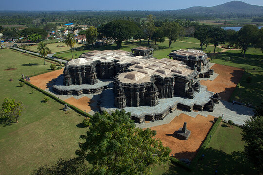 Aerial view of the ancient, elaborately carved Ishvara Temple complex standing majestically amidst lush greenery, Arasikere, Karnataka, India.