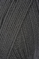 a detailed, close-up shot of a dark gray ball of yarn, highlighting its woven texture