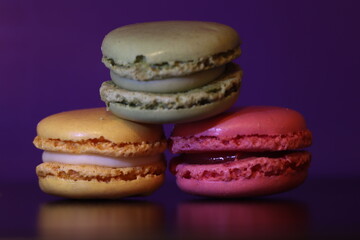 Colorful Macarons on a Reflective Surface with a Purple Background