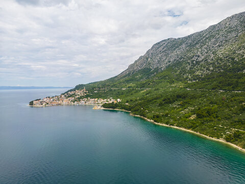 Aerial view of the village nestled where the rugged mountain meets the tranquil turquoise sea, Igrane, Split-Dalmatia County, Croatia.