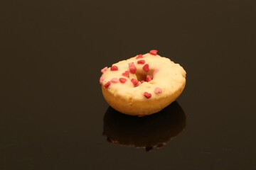 Close-Up of a Heart-Decorated Donut on a Reflective Black Surface