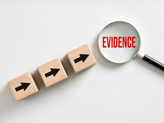 Magnifying glass showing evidence and wooden cubes with arrows pointing towards it