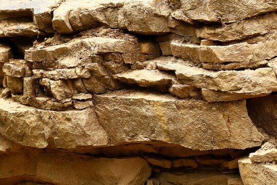A close-up of the texture of the weathered wall of stratigraphic layers in an abandoned mine.