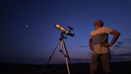Amateur astronomer using telescope for watching stars, Moon, planets and other celestial objects...
