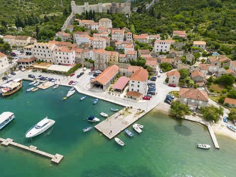 Aerial view of the harbor and the ancient walls, where the turquoise water meets the old stone buildings, Mali Ston, Dubrovnik-Neretva County, Croatia.