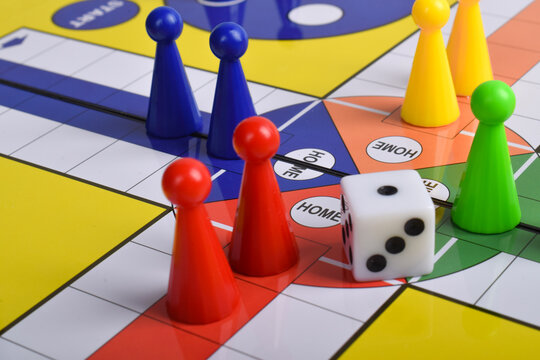 Ludo game board with figures and dice isolated on white background, close up